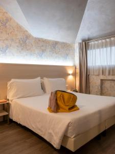 Un dormitorio con una cama con una bolsa amarilla. en Hotel Embassy, en Pero