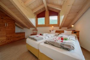 2 bedden in een kamer met houten plafonds bij Volga Loira Senna - Happy Rentals in Livigno