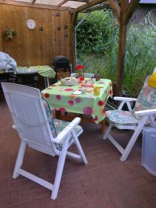 eine Terrasse mit einem Tisch, 2 Stühlen und einem Tisch in der Unterkunft Attraktives Häuschen Glogauer in Hamburg