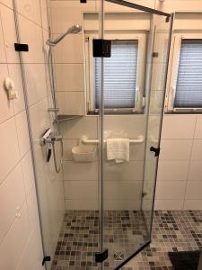 um chuveiro com uma porta de vidro na casa de banho em Ferienwohnung Ant Dopke em Krummhörn