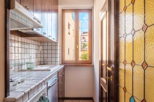ローマにあるTrastevere Leopard'Oro Apartmentのシンクと窓のあるキッチン +17枚の写真