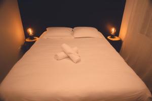 - un lit avec 2 serviettes blanches et 2 bougies dans l'établissement Le Verlaine, T4 en triplex, à Tours