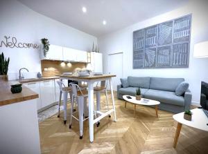 a kitchen and living room with a couch and a table at Hypercentre Appart 2 à4 pers Calme & Cosy avec Terrasse Privée in Nantes