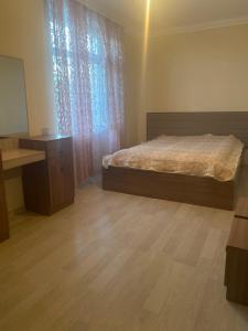 a bedroom with a bed and a desk and a mirror at Happy home Narimanov in Baku