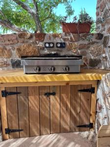 a outdoor kitchen with a stove on a stone wall at Chambres d'hôtes Gîte Saint Roch in Tuchan