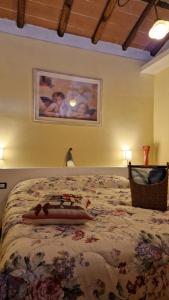 1 dormitorio con 1 cama grande con colcha de flores en La casa nella vigna [colline del vino], en Capannori