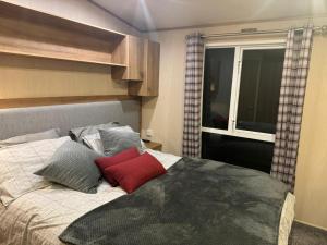 1 dormitorio con cama con almohadas y ventana en Nick's Retreat, en Clitheroe