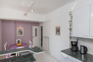 a kitchen with a purple table in a room at Apartment Rea in Dubrovnik