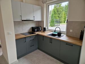 a kitchen with white cabinets and a window at Domek Pod Klimczokiem in Bystra
