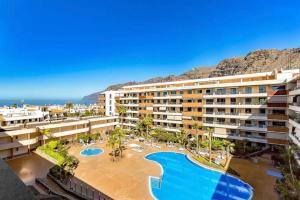 an apartment building with a swimming pool and a resort at Balcón De Los Gigantes, Puerto de Santiago in Puerto de Santiago