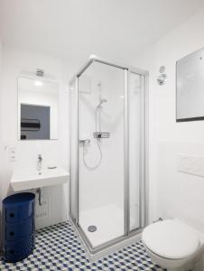 a bathroom with a shower and a toilet and a sink at POHA House Büchel in Aachen