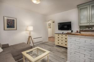 uma sala de estar com um sofá e uma televisão de ecrã plano em Apartman “Destiny” em Rijeka