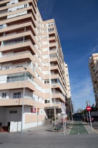 un edificio de apartamentos alto con bicicletas estacionadas frente a él en Alta Mar by Gades Gestión, en Cádiz