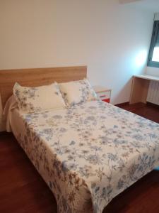 a bedroom with a bed with a floral bedspread at La casita de Miguel, con garaje y piscina in Zamora