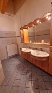 a bathroom with two sinks and a large mirror at Pension Bischof Lachtal in Lachtal