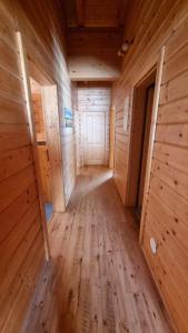 a hallway in a wooden cabin with wooden floors at Pension Bischof Lachtal in Lachtal