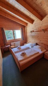 a bedroom with a large bed in a wooden cabin at Pension Bischof Lachtal in Lachtal