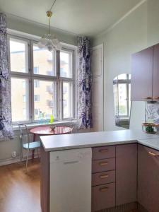a kitchen with a counter and a table and a window at Lovely Vintage Suite in Helsinki