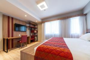 um quarto de hotel com uma cama e uma secretária em Hotel Laghetto Stilo Higienópolis em Porto Alegre