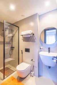 a bathroom with a toilet and a sink and a shower at Cozy 2 Bedroom Apt at Escada (506) in Nairobi