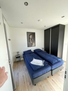 una camera con un grande letto blu di Chalet Meeresblick Zweite Reihe Haus Nr 250 a Enkhuizen