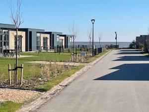 una strada vuota accanto a un edificio e all'oceano di Chalet Meeresblick Zweite Reihe Haus Nr 250 a Enkhuizen