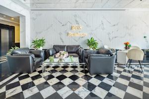 een lobby met zwarte lederen meubels en een geruite vloer bij MK Residence By Azco Holiday Homes in Dubai