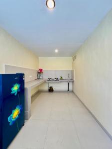 an empty room with a kitchen with a blue refrigerator at Dega Gardens in Canggu