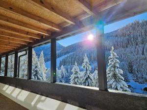 a room with a view of the snow covered trees at Kinder- und Familienhotel Nockalm in Innerkrems