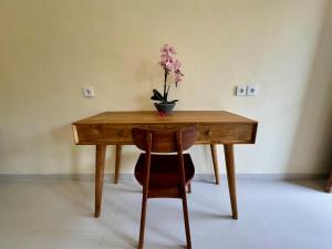 a wooden table with a vase of flowers on it at Dega Gardens in Canggu
