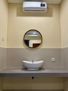 een badkamer met een wastafel en een spiegel bij Dega Gardens in Canggu