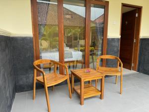 een kamer met 2 stoelen en een tafel en een tafel bij Dega Gardens in Canggu +37 foto's