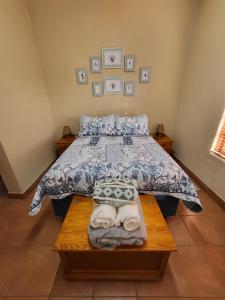 ein Schlafzimmer mit einem Bett mit Handtüchern auf einem Holztisch in der Unterkunft Home on a Hill Accommodation in Tzaneen