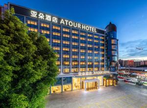 廈門市にあるAtour Hotel Xiamen Gaoqi Airport Chenggong Avenueの建物正面の看板のあるホテル