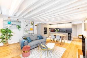 een woonkamer met een bank en een tafel bij Appartement Vertus in Parijs