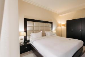 um quarto com uma grande cama branca e 2 candeeiros em Paris Hotel Yerevan em Yerevan