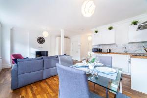 a living room with a blue couch and a table at Brand New Self-Contained 1 BDR Apt in Paddington in London