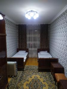 een slaapkamer met 2 bedden en een tapijt bij Dushanbe intourist apartment in Dushanbe