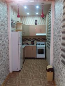 een keuken met een witte koelkast en een fornuis bij Dushanbe intourist apartment in Dushanbe
