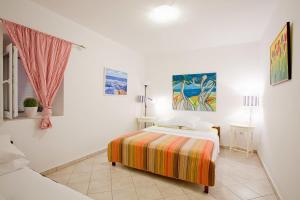 a white bedroom with a bed and two tables at Apartments Ferina in Poljana
