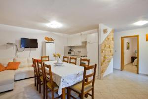 a living room with a table and chairs and a couch at Apartments Ferina in Poljana