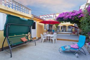a patio with a table and chairs and an umbrella at Apartments Ferina in Poljana +23 photos