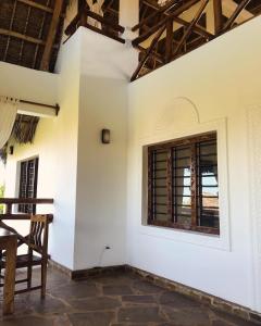 um quarto com paredes brancas e uma janela em Beach Way Villa em Malindi