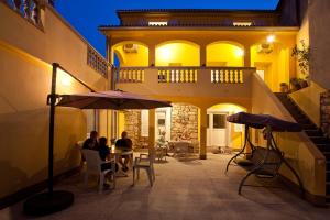 a group of people sitting at a table under an umbrella at Apartments Ferina in Poljana