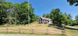 una casa en la cima de una colina con vallas de madera en Långasjönäs Camping & Stugby en Karlshamn