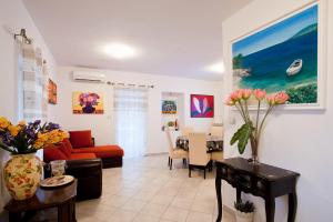 a living room with a couch and a table with flowers at Apartments Ferina in Poljana