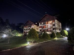 un gran edificio por la noche con sus luces encendidas en Charmoso recanto na serra, en Teresópolis