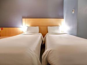 duas camas sentadas uma ao lado da outra num quarto em ibis Rio de Janeiro Barra da Tijuca no Rio de Janeiro