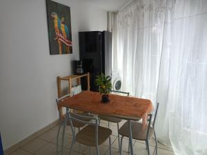 een tafel en stoelen in een kamer met een raam bij blue and yellow, appartement au calme, avec piscine, WIFI in Saint-Denis