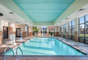 a pool in a hotel with windows and a large pool at Hampton Inn & Suites Dallas-Allen in Allen
